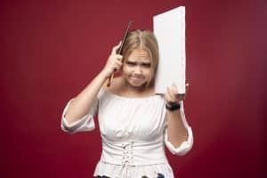 Femme confuse portant une brosse et une toile.